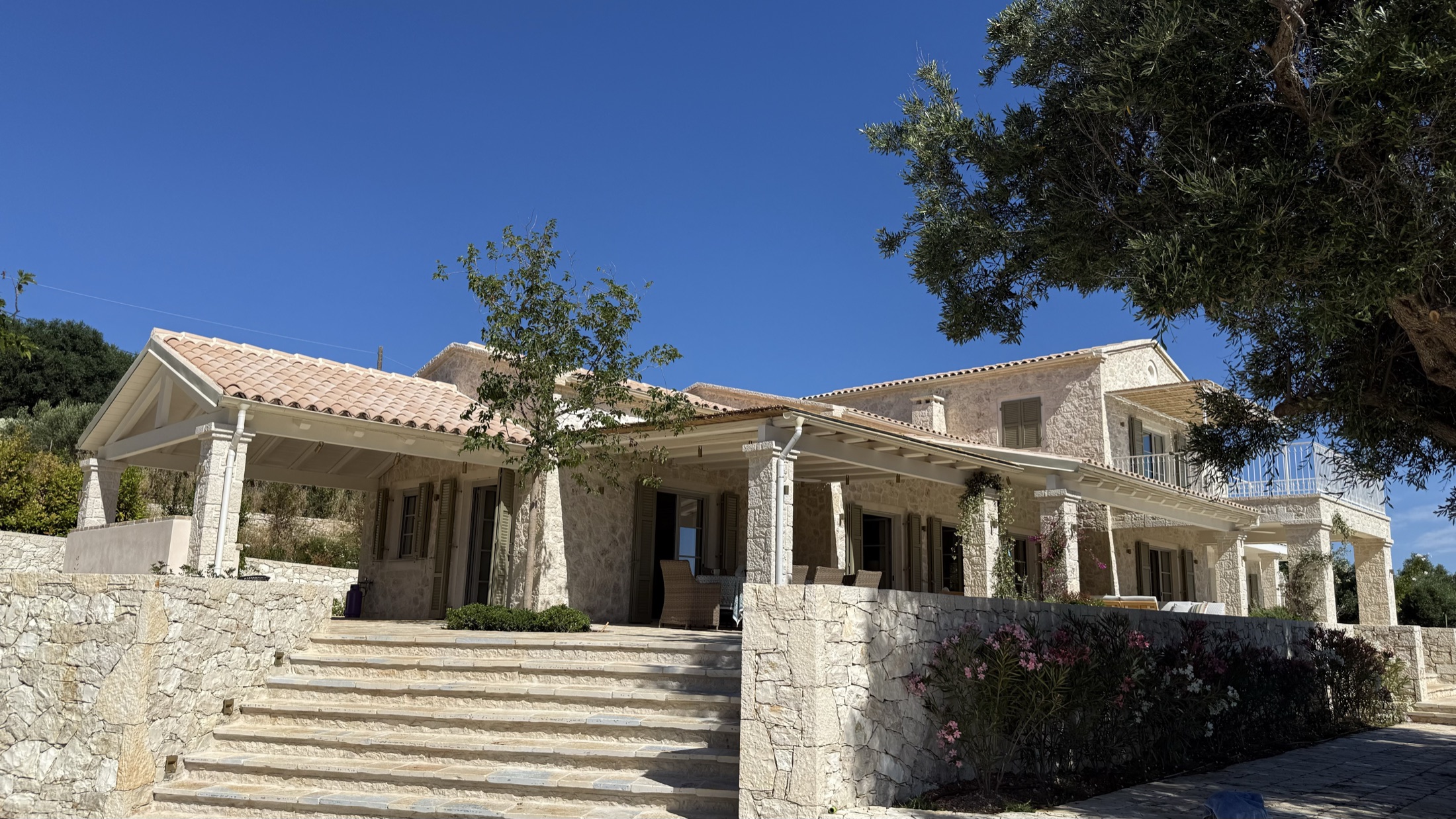 Villa No. 4, A hilltop villa in cream-to-honey limestone, terraced by dry-stack garden walls.