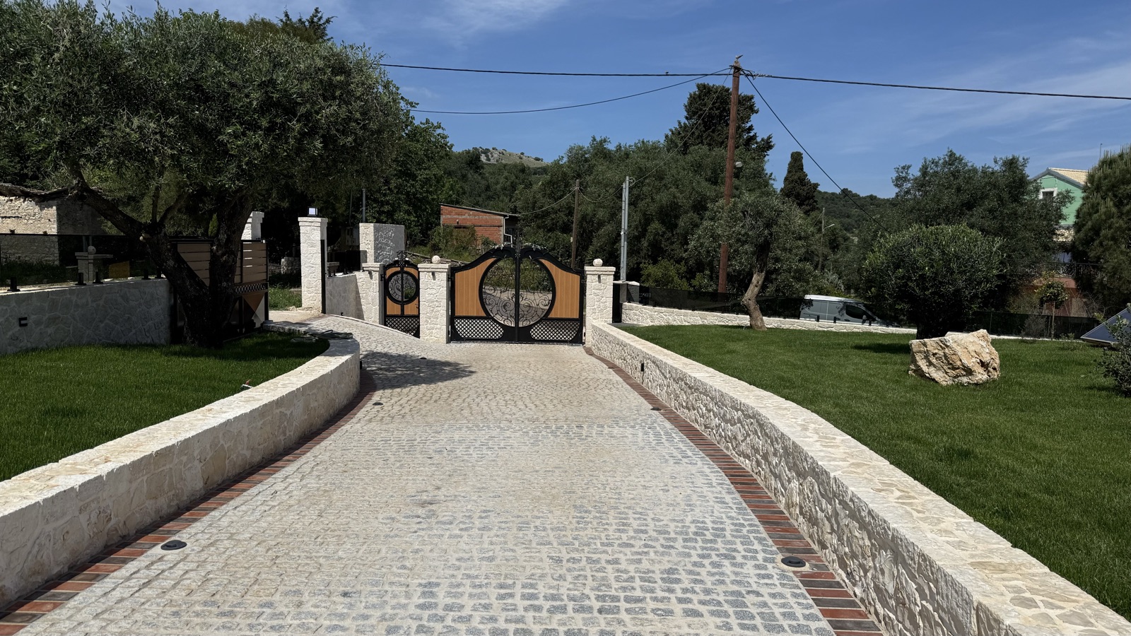 Cobbled limestone driveway leading to ornate iron and timber gates, Villa No. 10, Corfu.