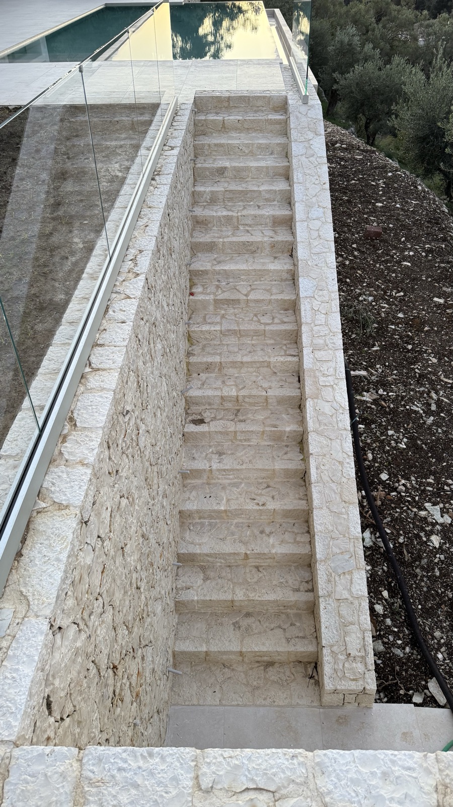 Dressed-stone pool surrounds, coping and garden steps, cut and set by hand along the north-east shore.